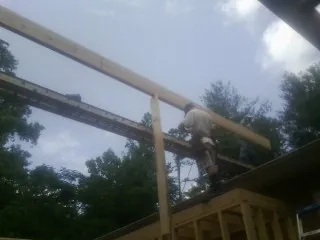 Carpenter setting a ridge beam over a new addition frame — Ice Dam Removal by Roofing Brothers in Kensington