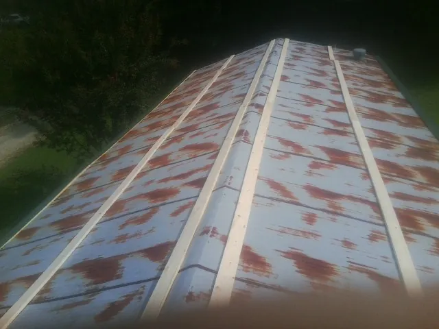 Rusted metal roof panels with new wood purlins before replacement — Storm Damage Roof Repair in Kensington by Roofing Brothers